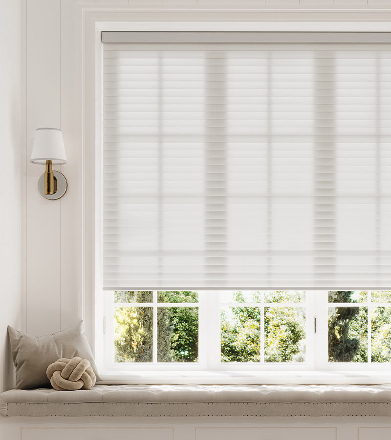 sonnette-shades-window-seat-light-gray-white-hinged-grid-windows-skyline-window-coverings Light-filtering white cellular window shade above a built-in window seat in a bright living room
